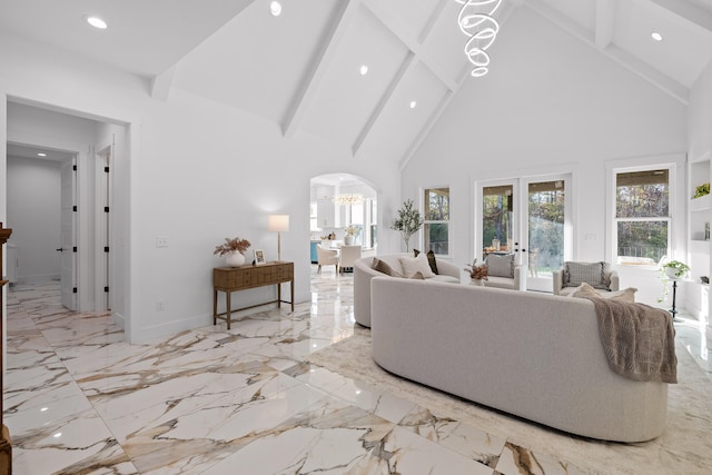 living room with beamed ceiling, a chandelier, high vaulted ceiling, and french doors