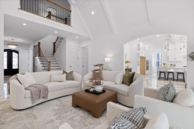 living room with beam ceiling, high vaulted ceiling, and french doors