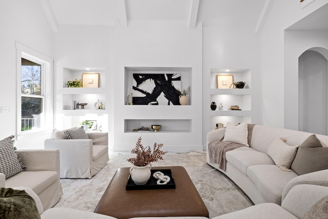 living room with beamed ceiling, built in features, and high vaulted ceiling