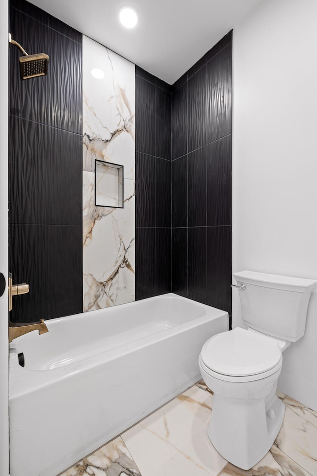 bathroom with shower / bathing tub combination, toilet, and tile walls