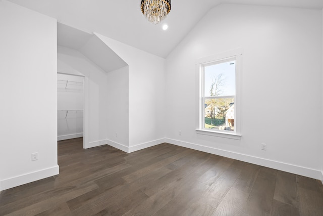 bonus room with dark hardwood / wood-style flooring, an inviting chandelier, and vaulted ceiling