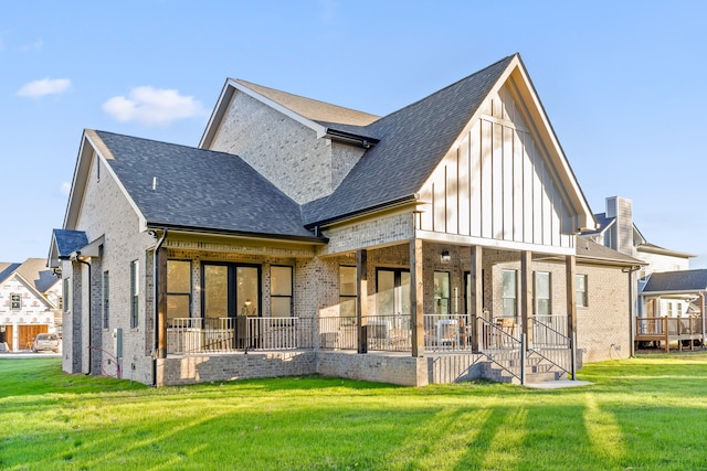 rear view of property featuring covered porch and a yard