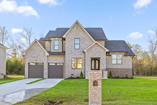 view of front of property with french doors, a garage, and a front lawn