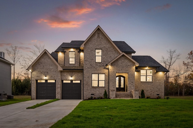 french country home featuring a garage, cooling unit, and a lawn