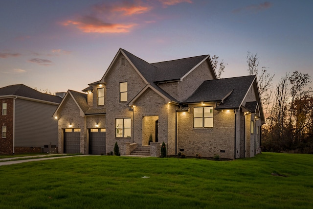 view of front of home with a lawn and a garage