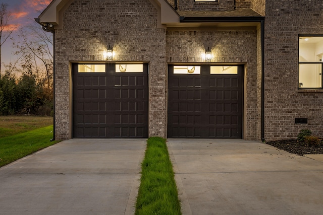 view of garage at dusk