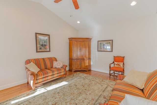 living room featuring ceiling fan, vaulted ceiling, and light wood-type flooring