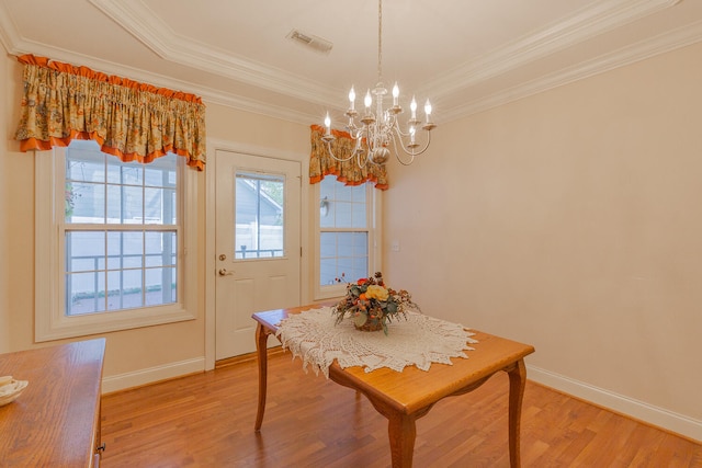 dining room featuring ornamental molding, a notable chandelier, and hardwood / wood-style flooring