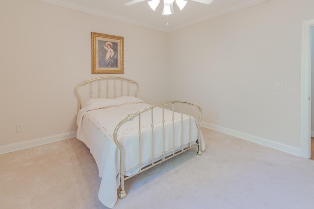 carpeted bedroom with ceiling fan and ornamental molding