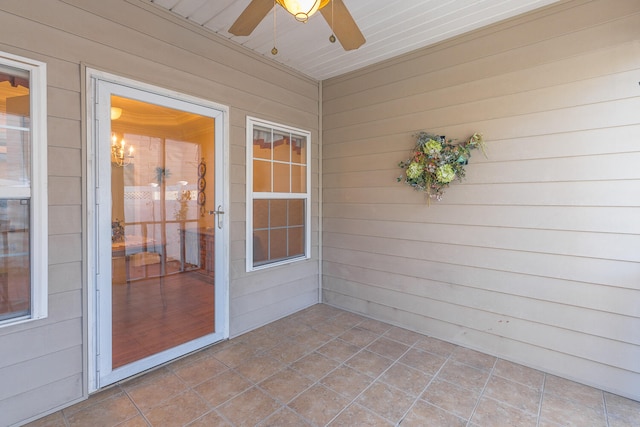 unfurnished sunroom with ceiling fan