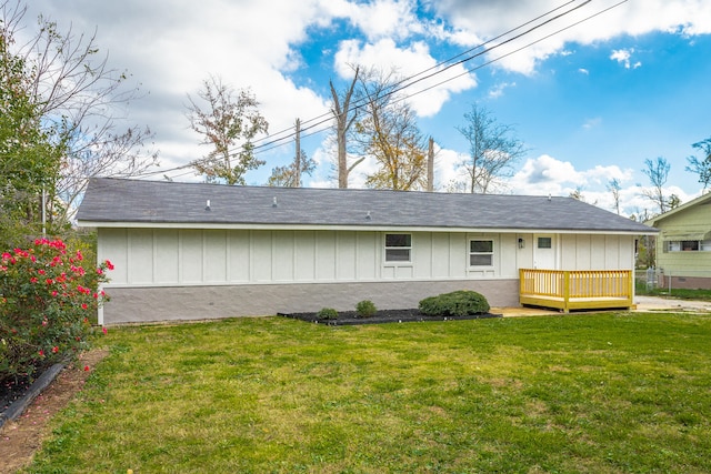 rear view of house featuring a wooden deck and a yard