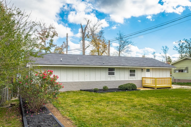 back of house featuring a lawn and a wooden deck