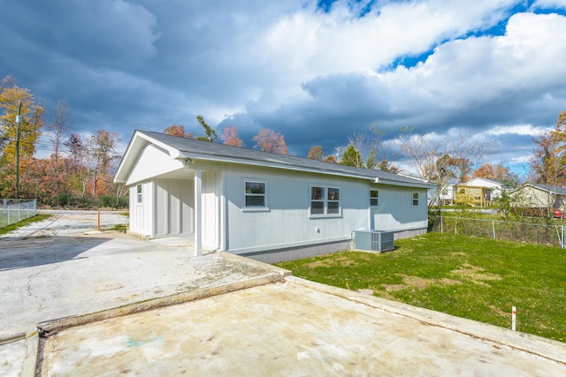 rear view of property with a yard and cooling unit