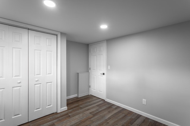 unfurnished bedroom with dark wood-type flooring and a closet