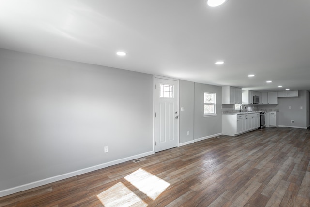 unfurnished living room with dark hardwood / wood-style floors