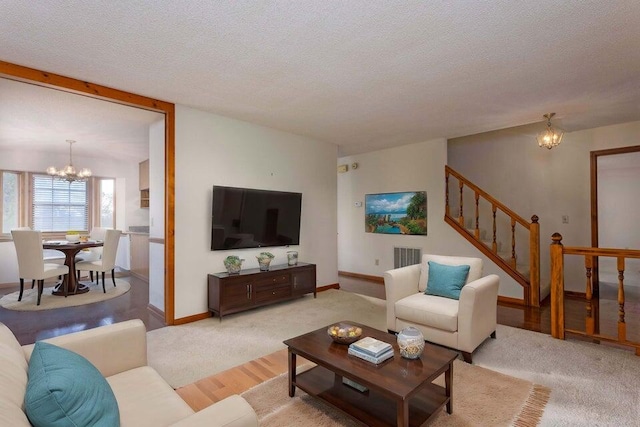 living room with a textured ceiling, light hardwood / wood-style flooring, and a notable chandelier