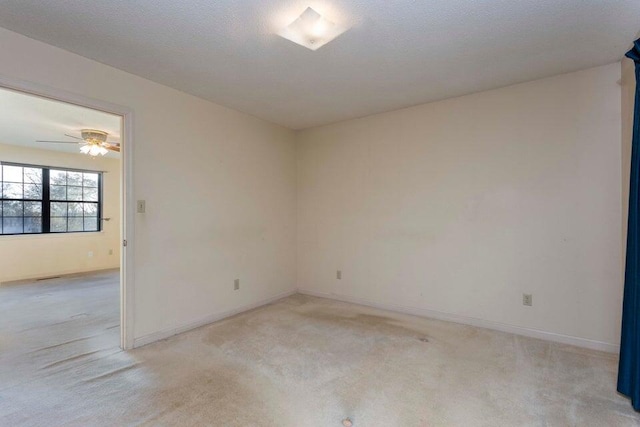 carpeted empty room with ceiling fan and a textured ceiling