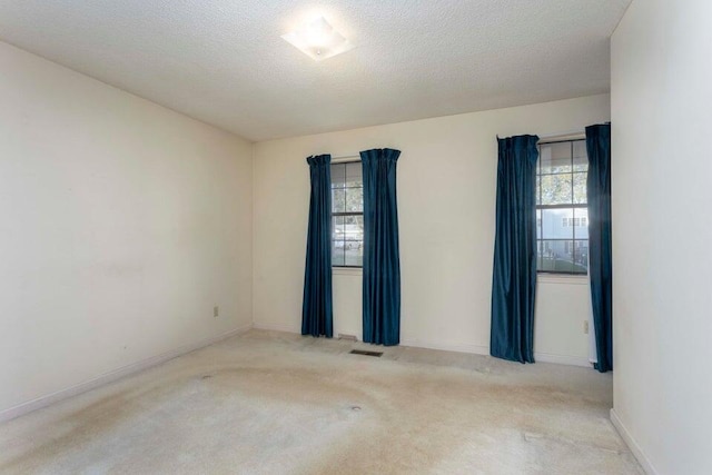 carpeted spare room with a textured ceiling