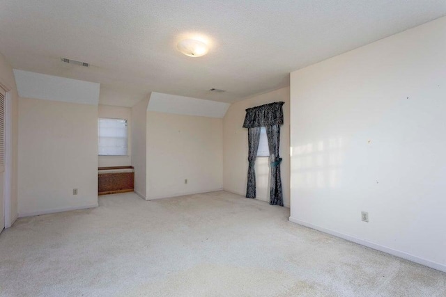 carpeted empty room featuring a textured ceiling