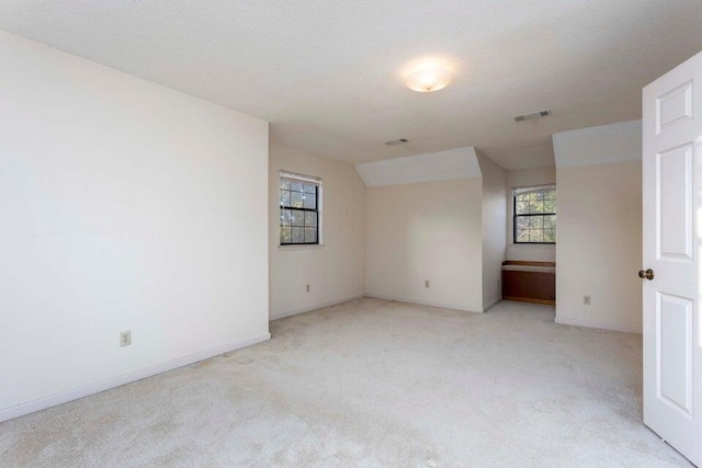 unfurnished room featuring light carpet and a textured ceiling