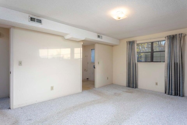 unfurnished room with carpet flooring and a textured ceiling