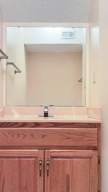 bathroom with vanity and a textured ceiling