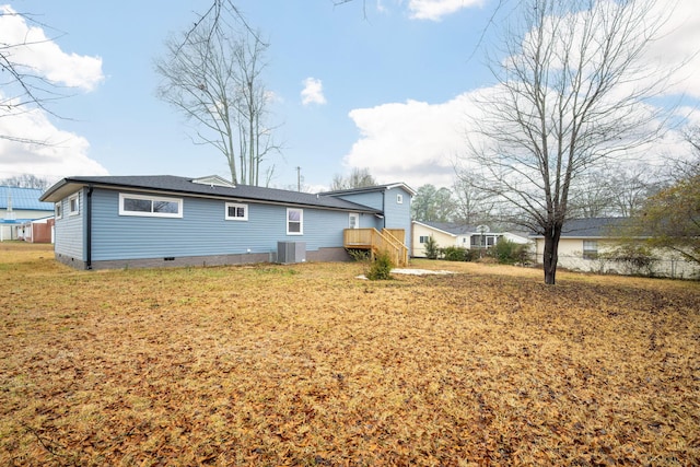 back of property featuring central AC unit and a lawn