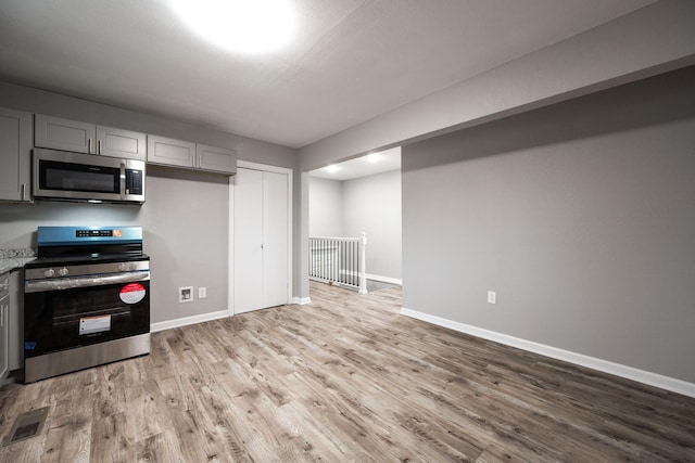 kitchen featuring appliances with stainless steel finishes, gray cabinets, and light hardwood / wood-style flooring