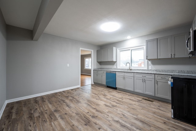 kitchen featuring a healthy amount of sunlight, stainless steel appliances, beam ceiling, and sink