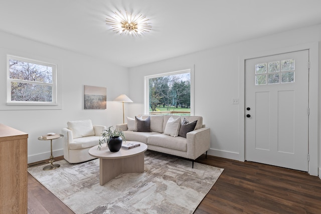 living room with dark wood-type flooring and a healthy amount of sunlight