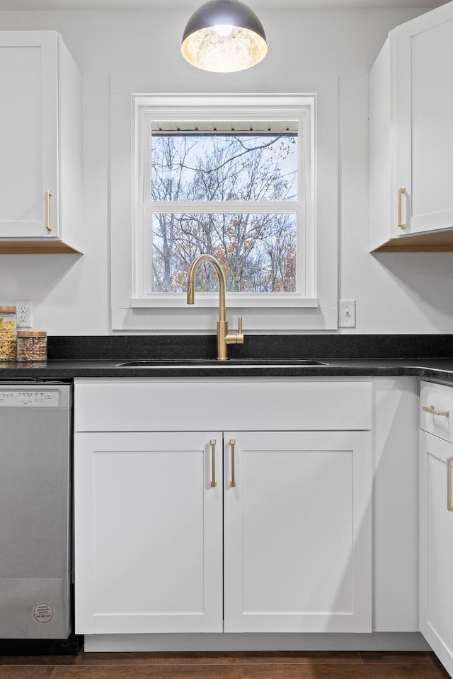 kitchen with white cabinets, stainless steel dishwasher, and sink