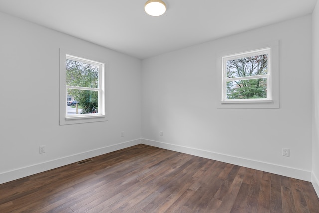 spare room featuring dark wood-type flooring