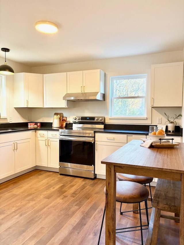 kitchen featuring white cabinetry, electric range, hanging light fixtures, and light wood-type flooring