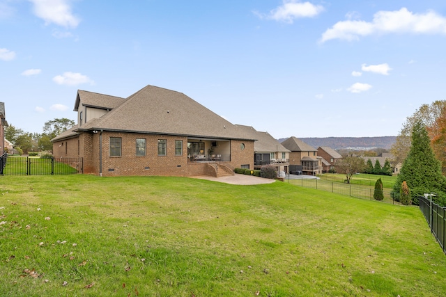 back of house with a yard and a patio