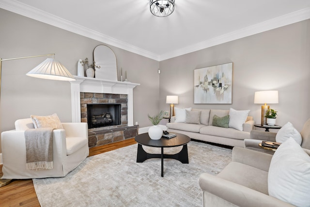 living room with crown molding, a fireplace, and wood-type flooring