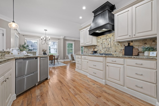 kitchen with hanging light fixtures, white cabinets, light hardwood / wood-style floors, and custom exhaust hood