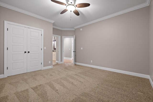 unfurnished bedroom with ceiling fan, a closet, carpet floors, and ornamental molding