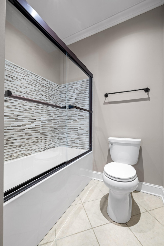 bathroom featuring toilet, tile patterned flooring, bath / shower combo with glass door, and ornamental molding