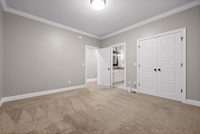 unfurnished bedroom with carpet floors, ornamental molding, connected bathroom, and a closet