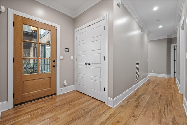 foyer featuring light wood-type flooring and ornamental molding