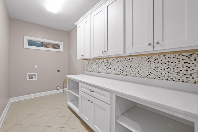 clothes washing area with cabinets, washer hookup, hookup for an electric dryer, gas dryer hookup, and light tile patterned floors