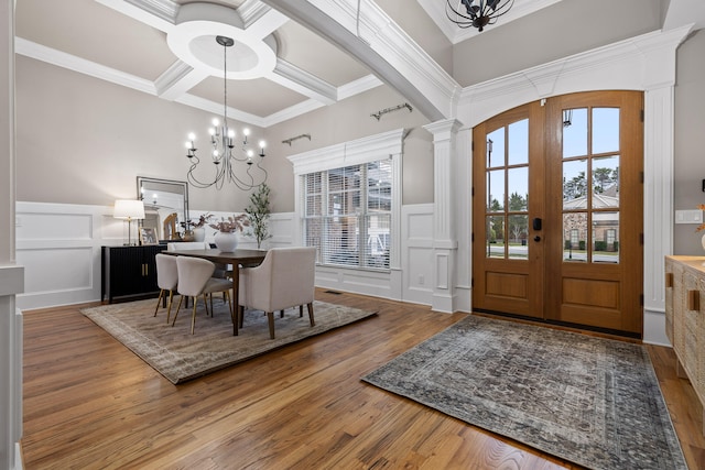 dining room with french doors, coffered ceiling, crown molding, hardwood / wood-style flooring, and a chandelier