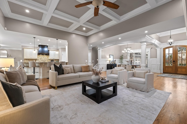 living room with ornate columns, crown molding, and light hardwood / wood-style flooring