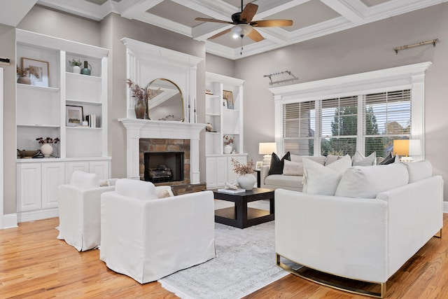 living room with ceiling fan, a fireplace, coffered ceiling, and light wood-type flooring