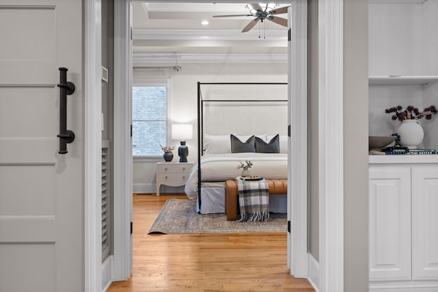 bedroom featuring ceiling fan, crown molding, and light hardwood / wood-style floors