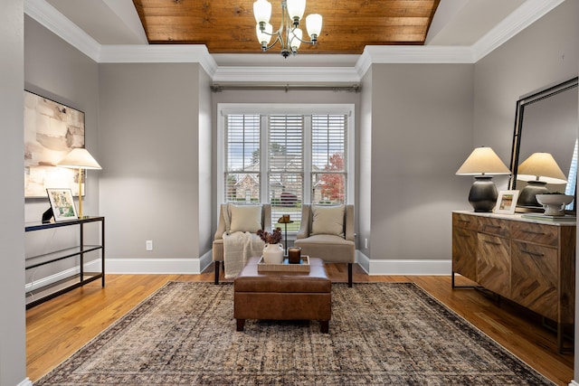 sitting room with hardwood / wood-style flooring, wooden ceiling, crown molding, and an inviting chandelier