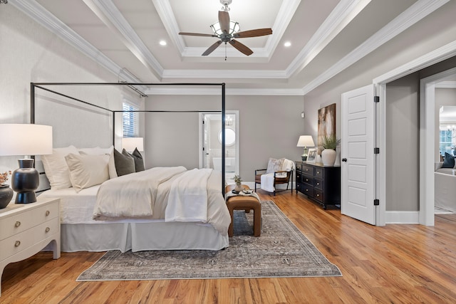 bedroom featuring a raised ceiling, ceiling fan, light hardwood / wood-style floors, and ornamental molding