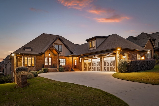 view of front of property featuring brick siding, a garage, concrete driveway, and a yard