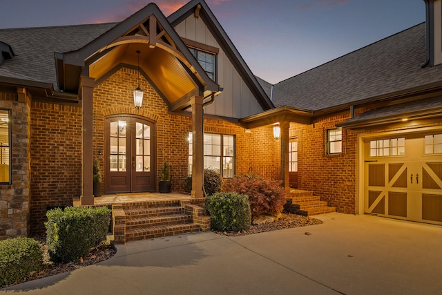 exterior entry at dusk with a garage and french doors