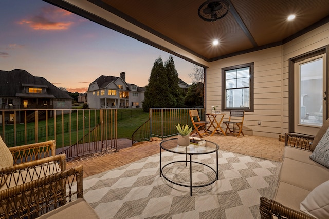 patio terrace at dusk featuring a yard